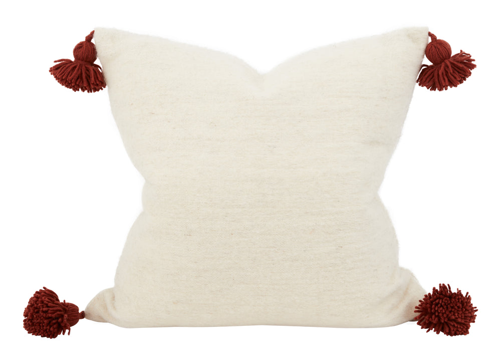 Bashir Floor Cushions, crafted from hand-spun, hand-dyed wool on traditional wooden looms in Morocco, feature a hidden zipper closure, a plush down and feather pillow insert, and charming pom-pom tassels in contrasting hues of ivory and Bordeaux.